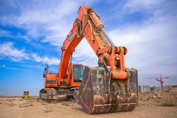 low-angle-photography-of-orange-excavator-under-white-clouds-1078884 (1)
